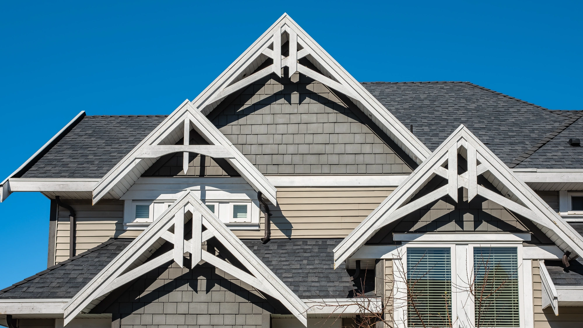 A home with gray and tan siding and a gray shingle roof