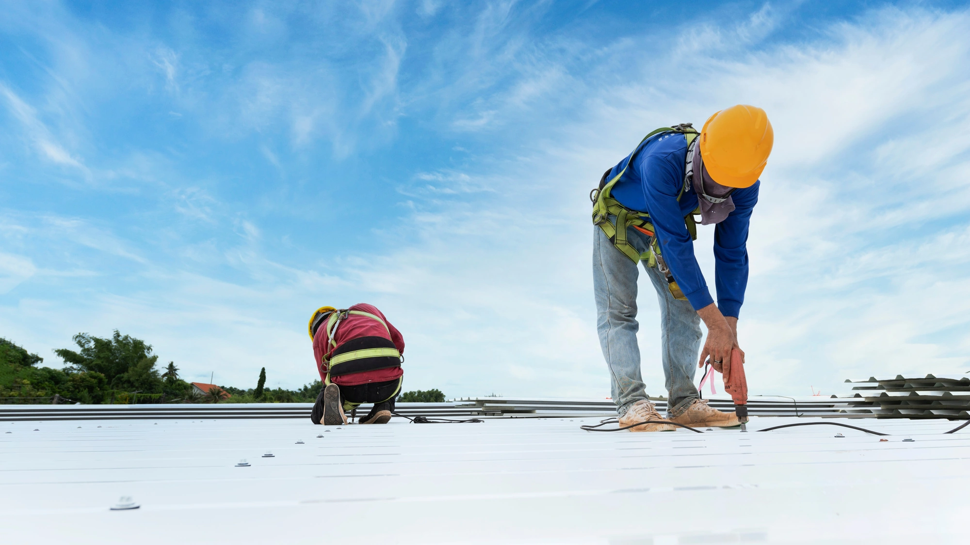 Two roofers repair a commercial roof