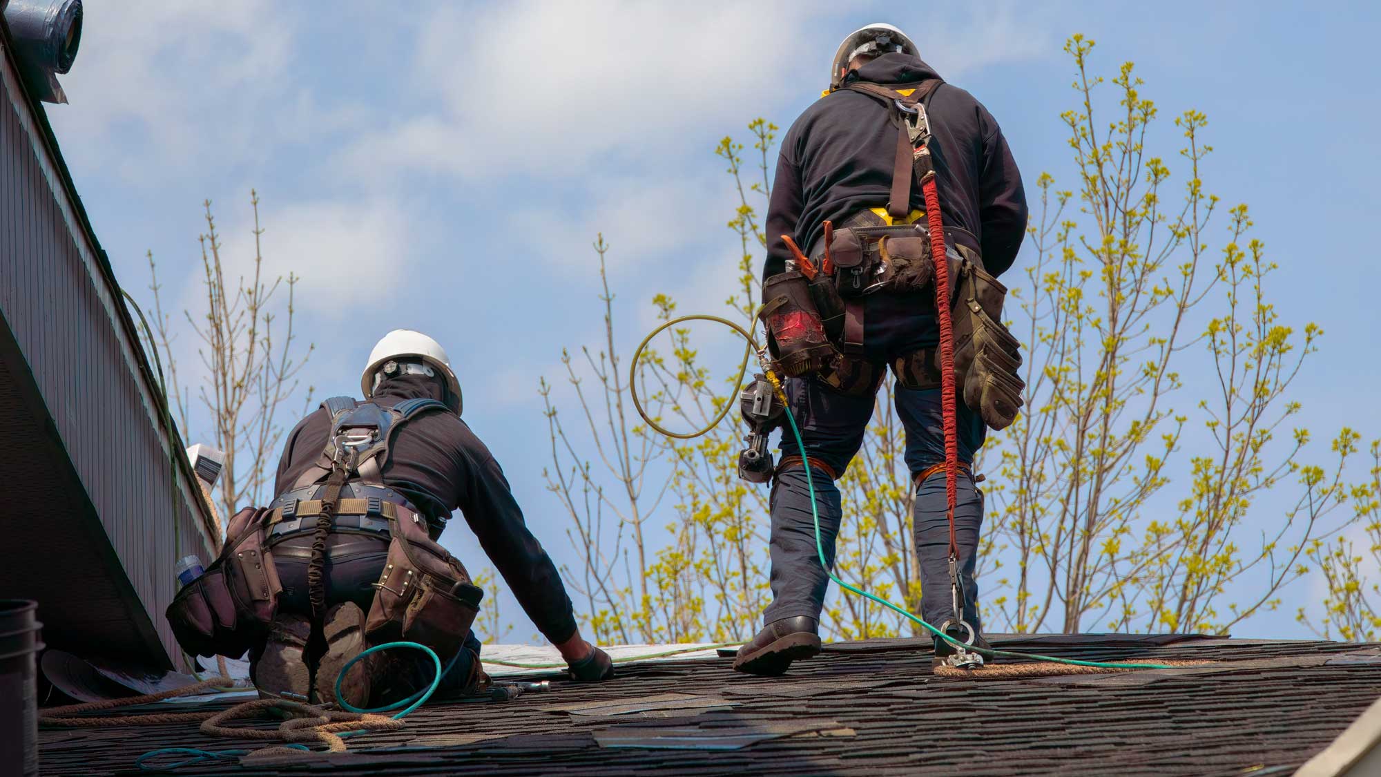 Two roofers completing roof repairs