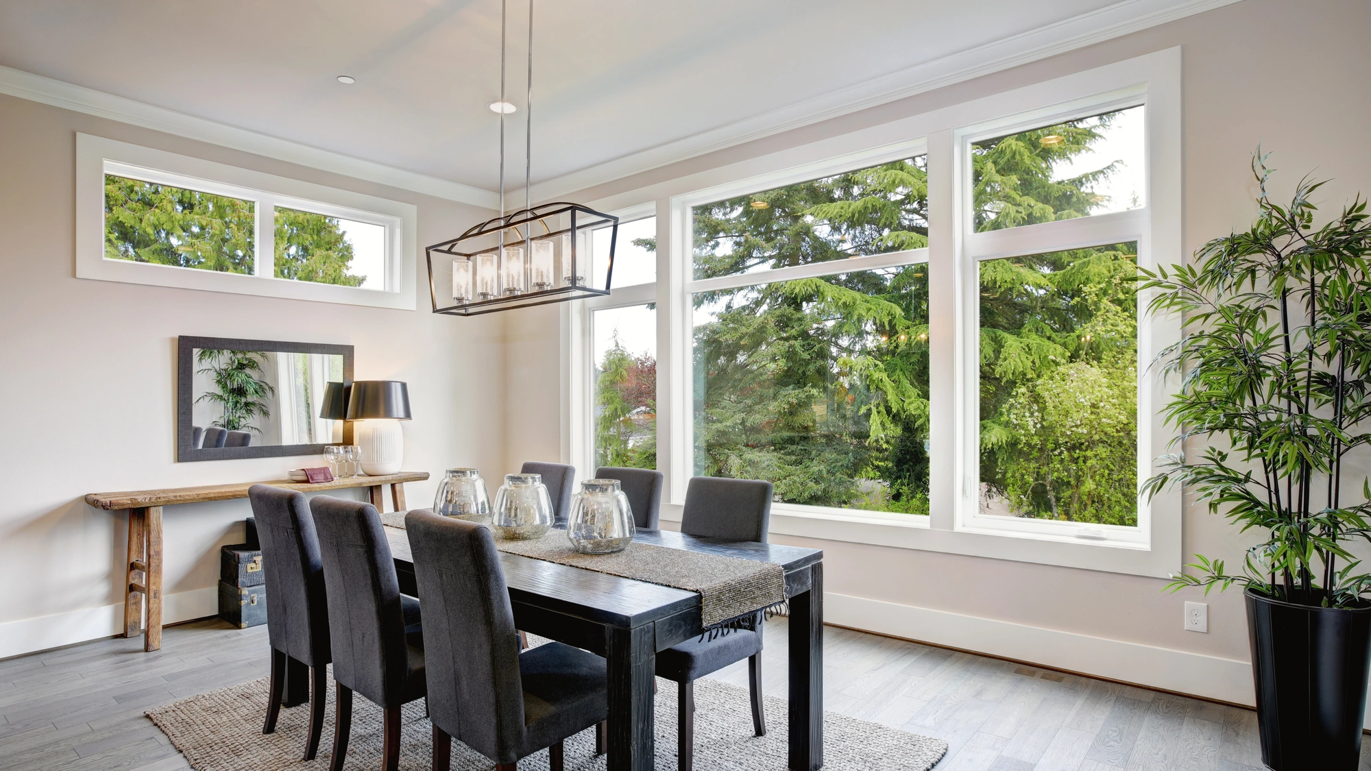 A dining room with large windows overlooking the trees