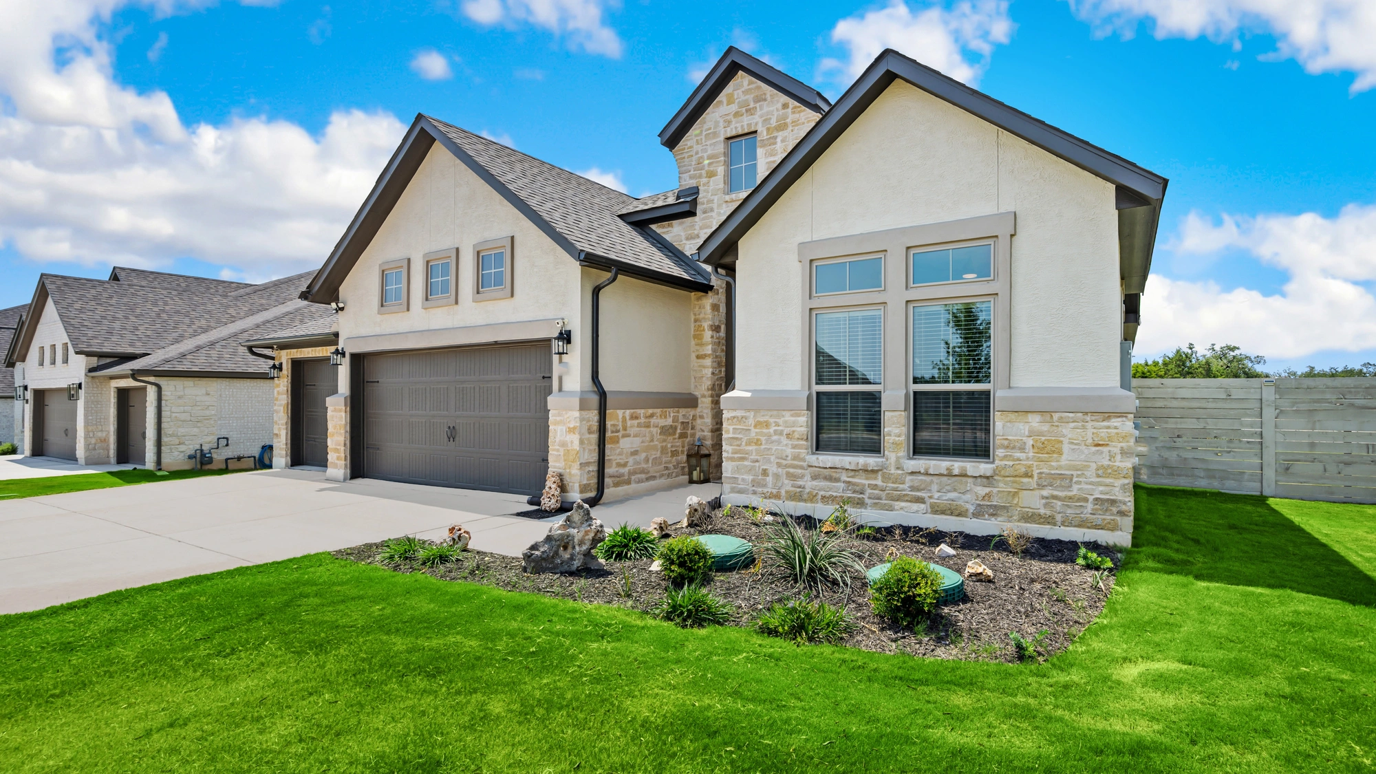 A large white-sided home with gray shingle roofing