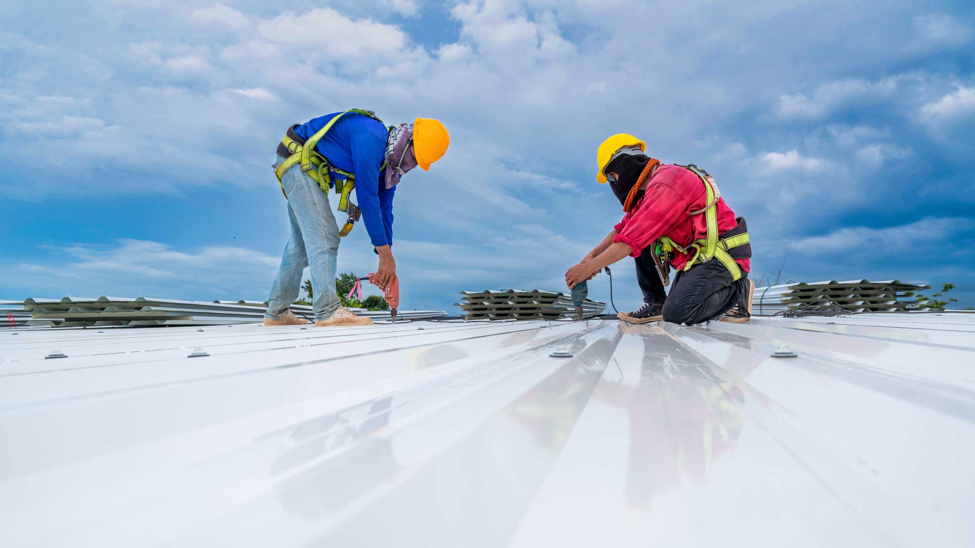 Two roofers installing a new commercial roof