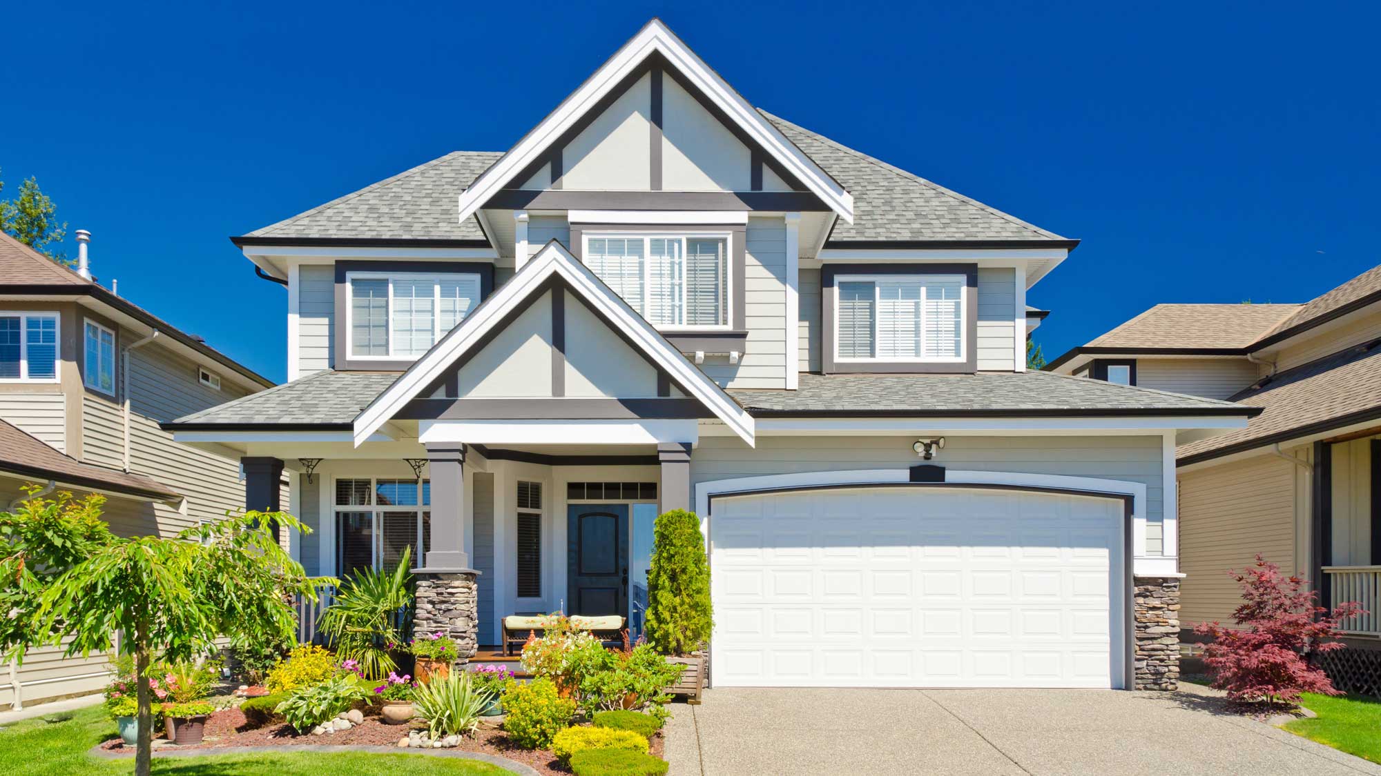 A white-sided home with gray trim and gray shingle roofing