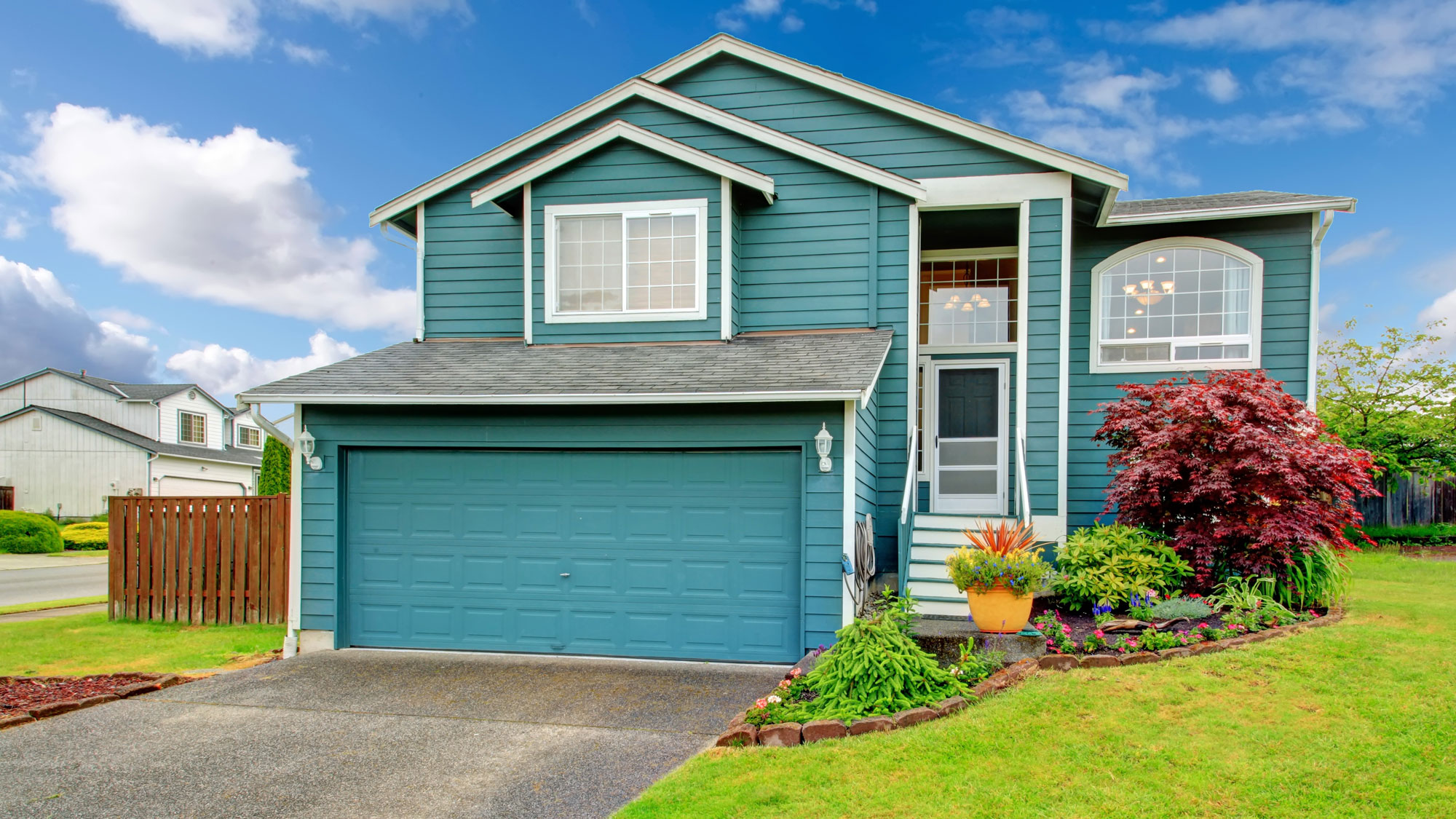 House with teal siding and flowerbeds