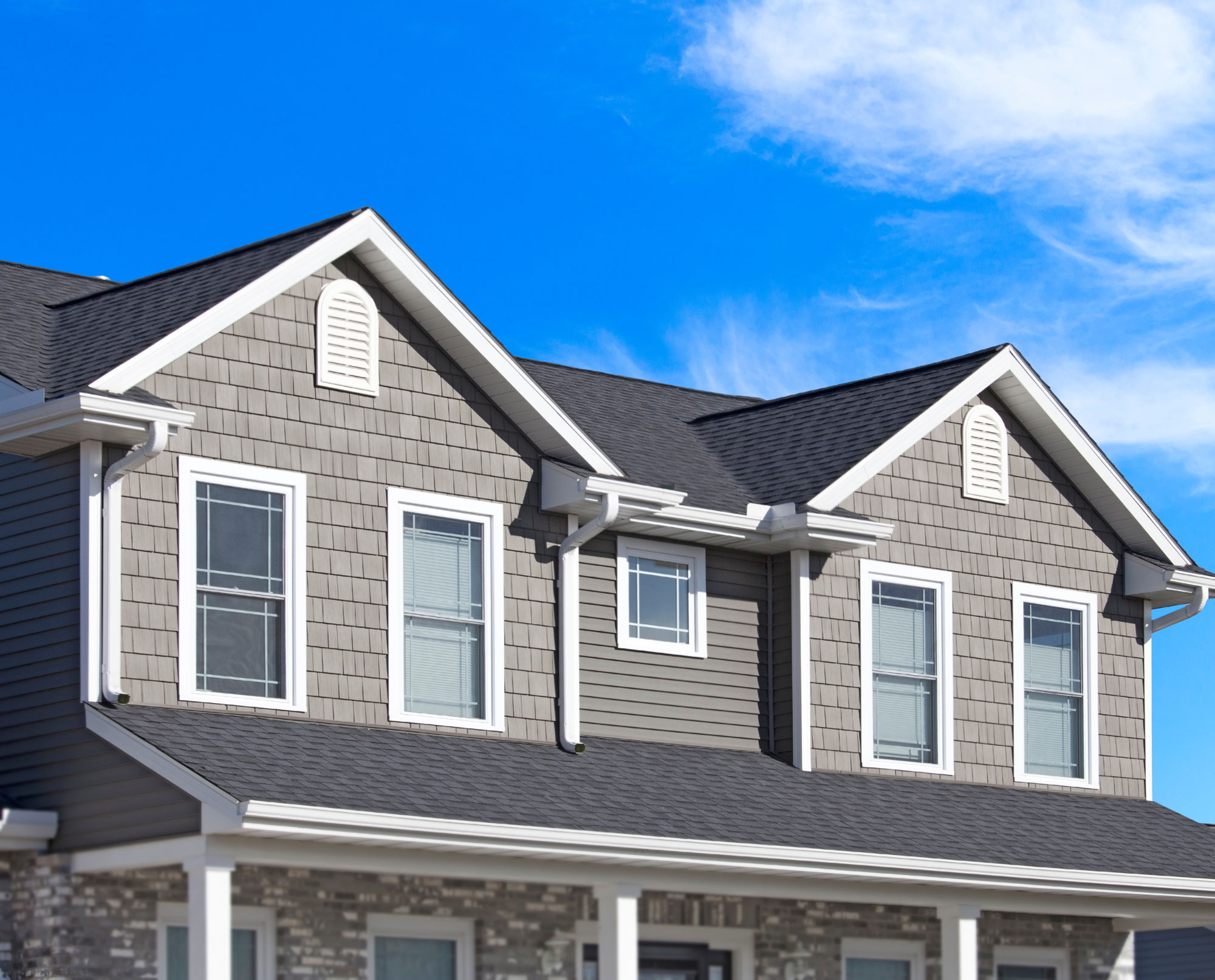 New house with pale gray siding and asphalt shingle roofing