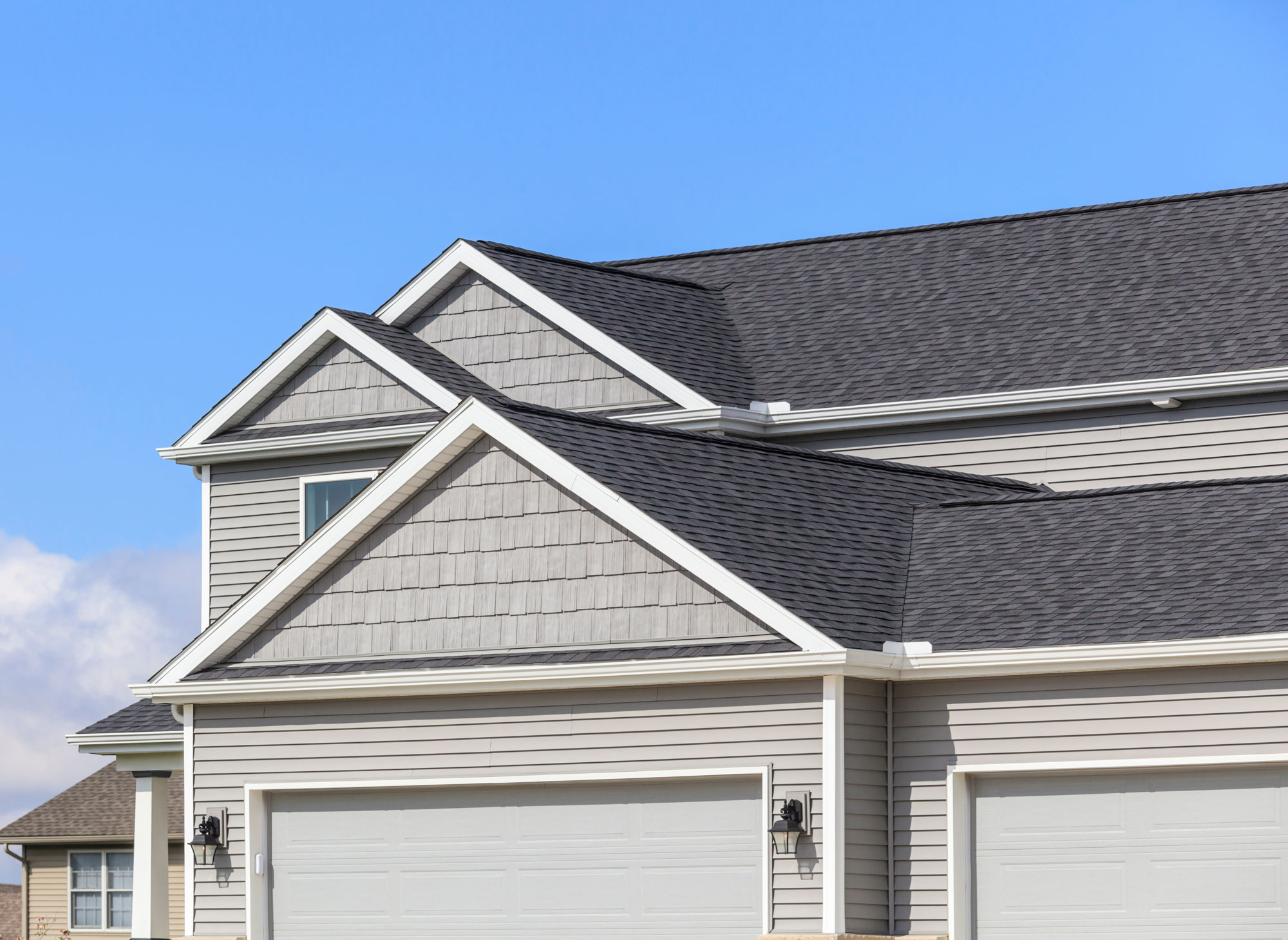 Single-family home with pale gray siding and gray asphalt shingle roofing