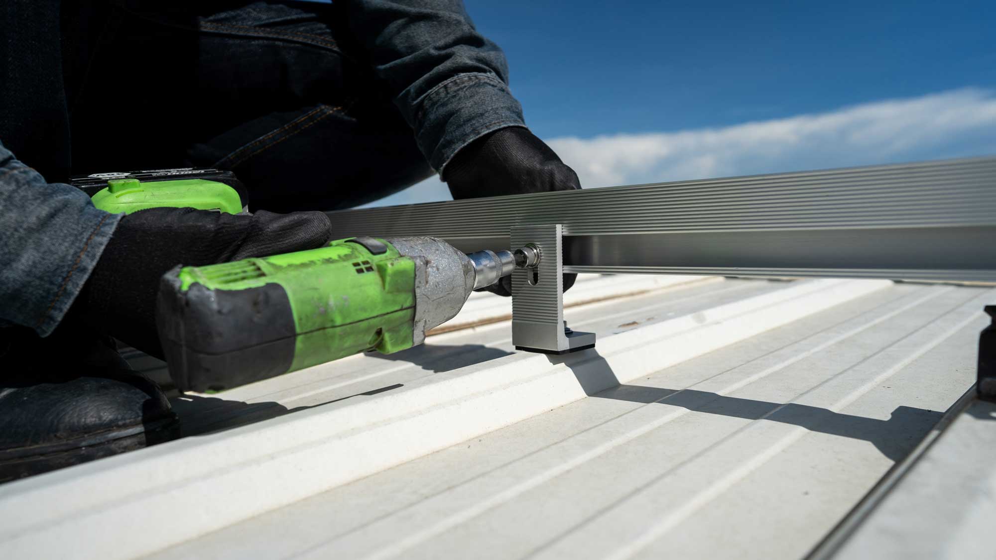 A roofer repairing a bracket on a commercial roofing system