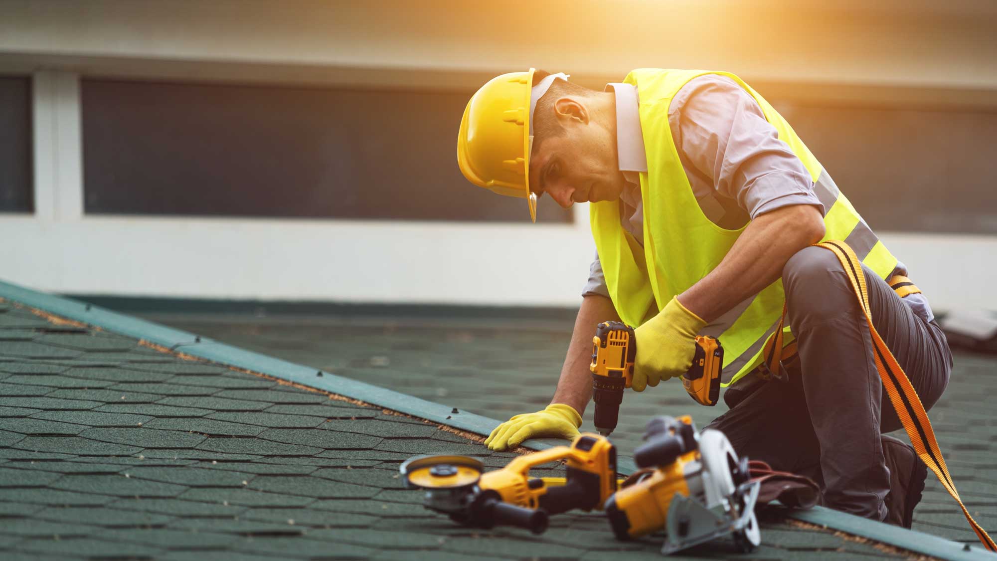 A roofer repairing a commercial asphalt shingle roof