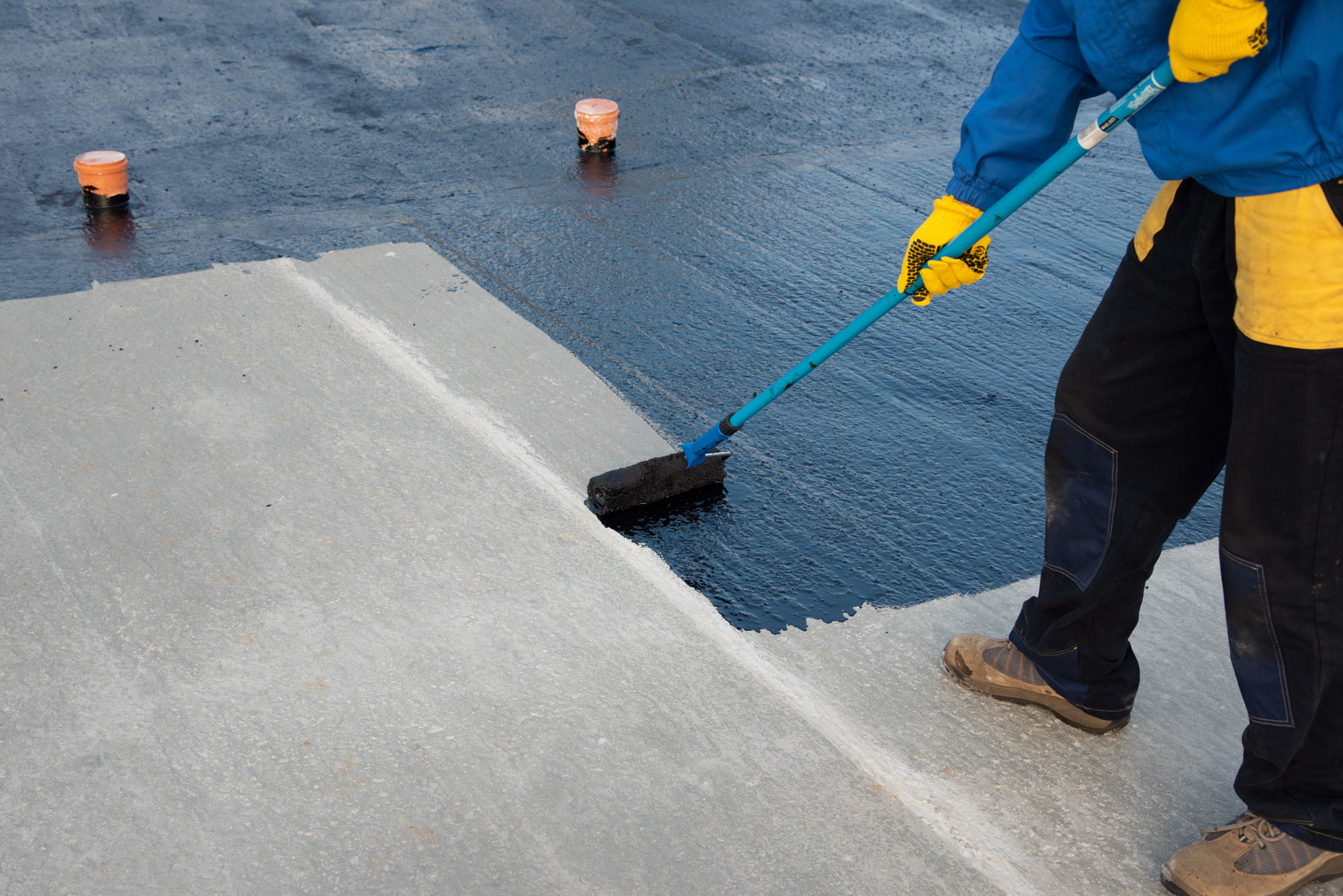 Roofer installing modified bitumen on flat roof