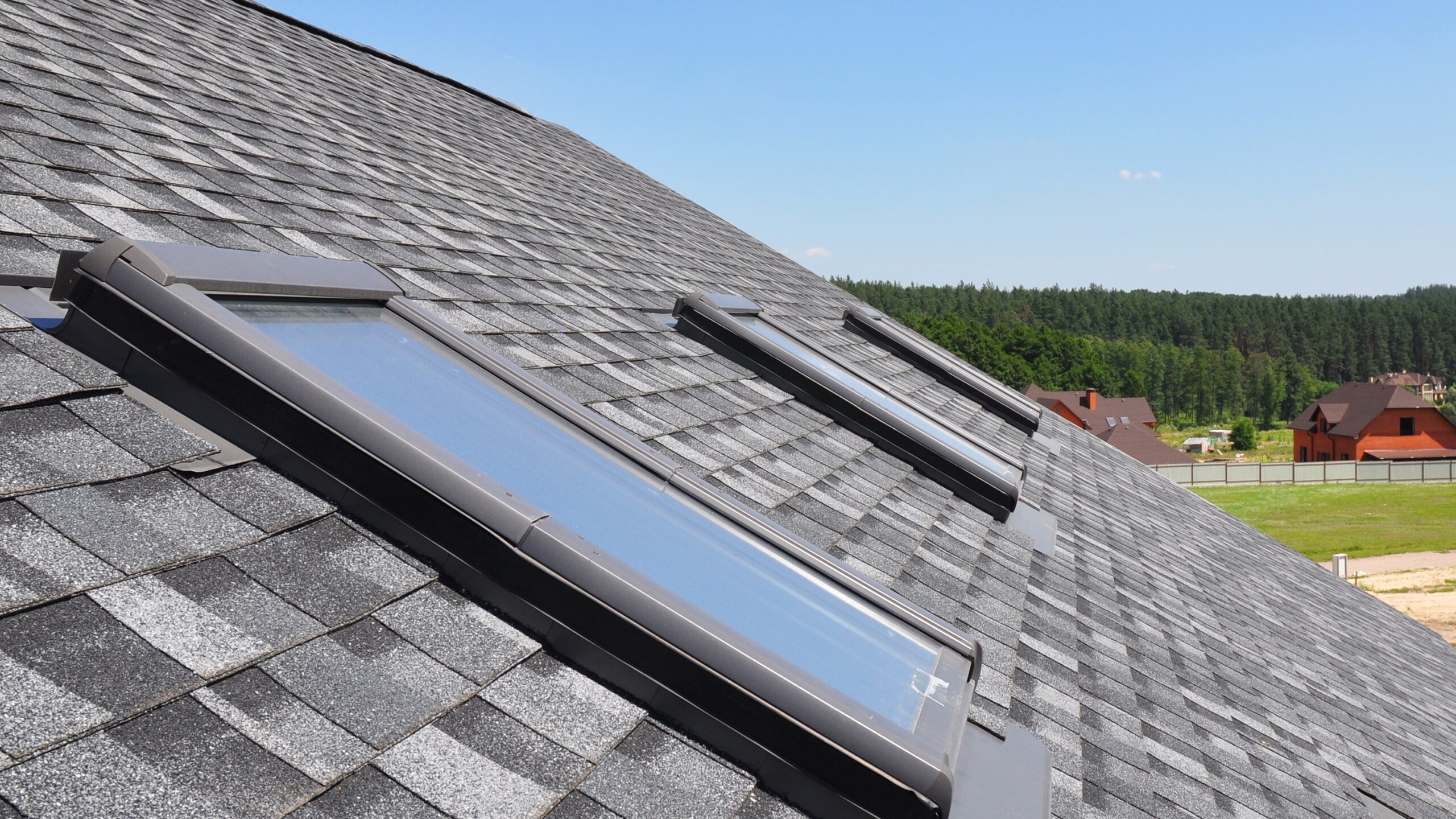 Closeup of a shingle roof with three skylights