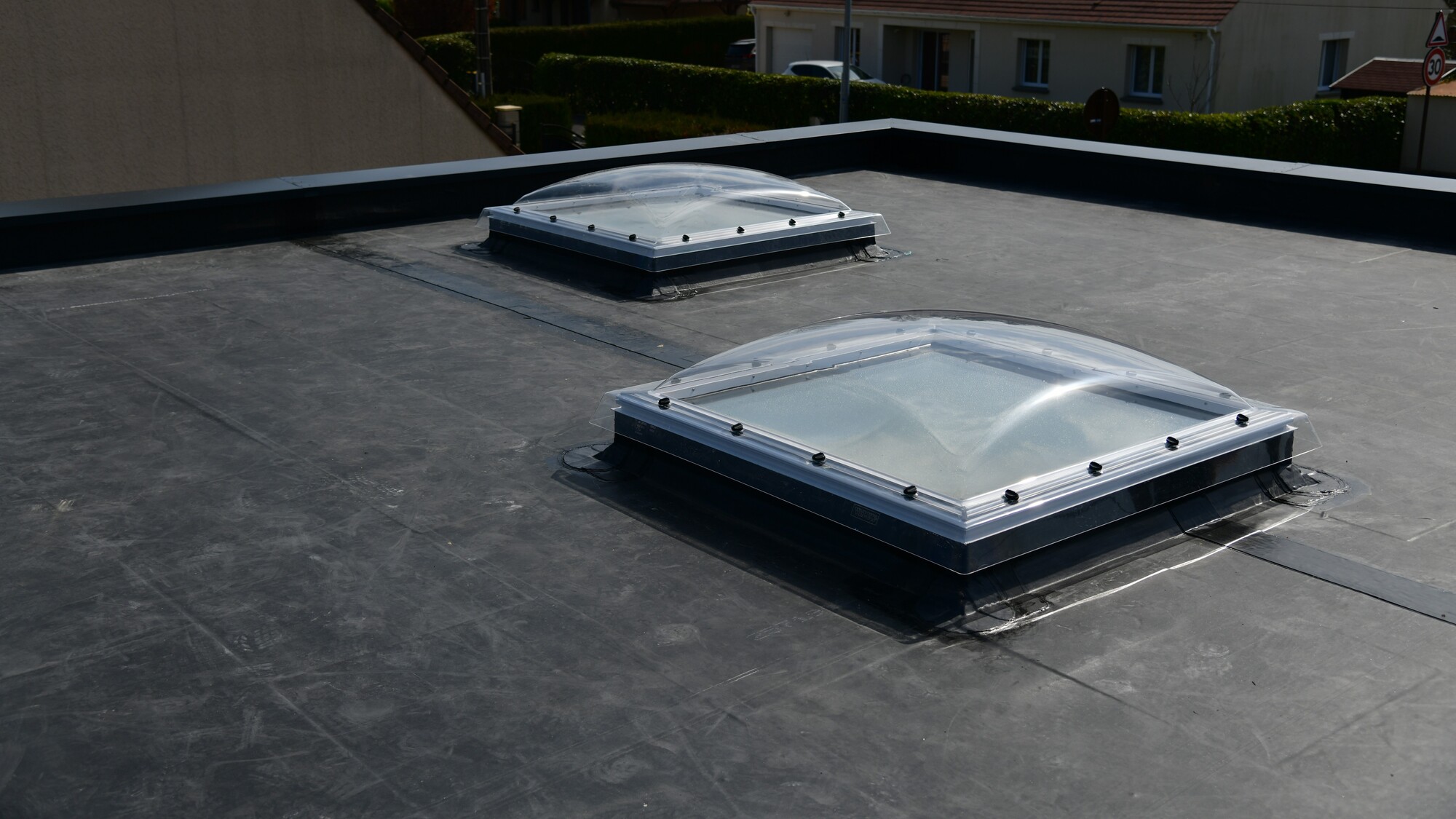 Close up of black EPDM commercial roof with two skylights