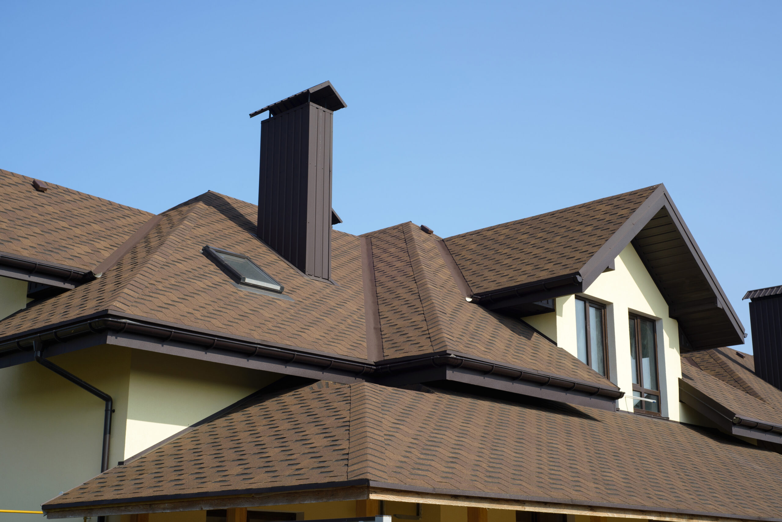 Fresh brown asphalt shingle roofing on a new home.