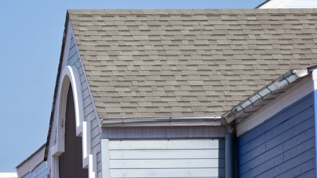 Close-up of an asphalt shingle roof on home with white siding